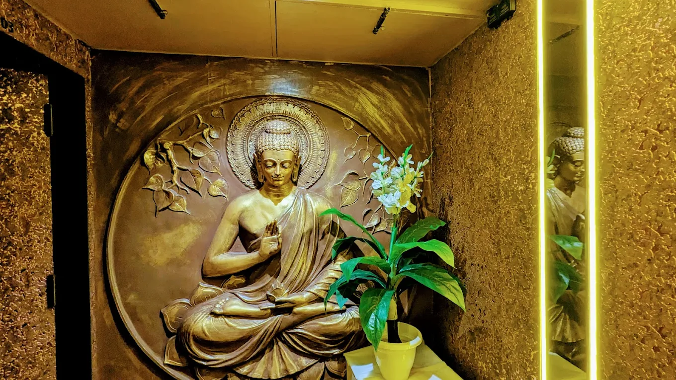 Lotus flowers floating in a stone bowl beside candles